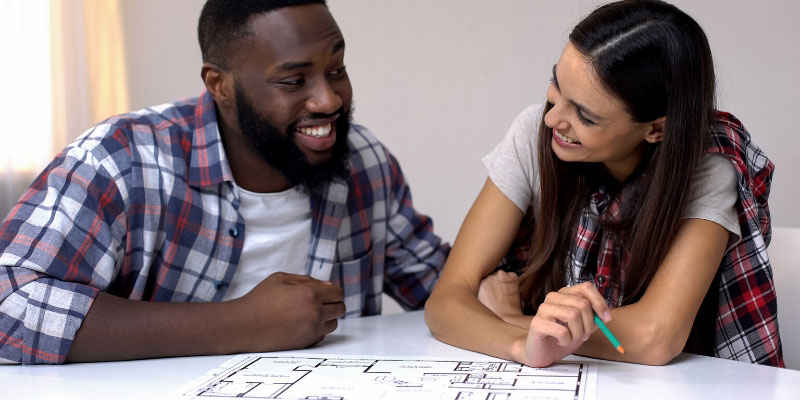 A couple looking over a floor plan of their dream home.